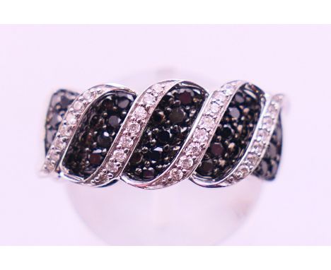 A 14 K gold black and white diamond ring. Ring size N. 7.4 grammes total weight.