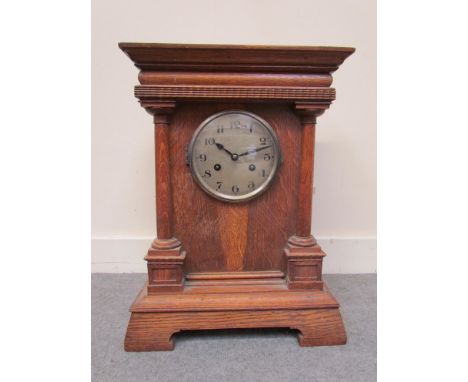 An early 20th Century oak mantel clock of architectural form with Arabic silvered dial, 8-day movement, 48cm high, key and pe