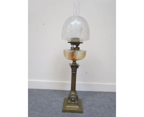A Victorian brass oil lamp of corinthian column form, lion mask detail, frosted glass shade 