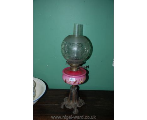 A Victorian glass Oil Lamp with etched glass shade and china reservoir with cast base.