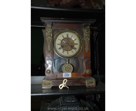 A decorative wood and brass pendulum Mantle Clock with winding key.