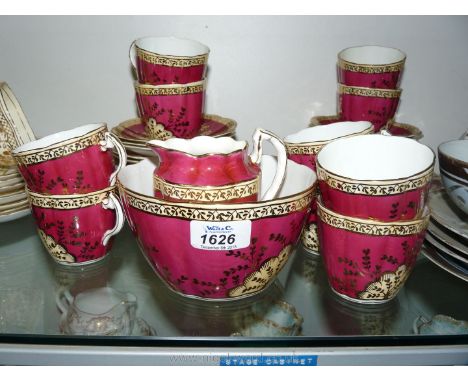 A red and gilt Teaset pattern no. 989 to include ten cups, eleven saucers, twelve tea plates, two bread and butter plates, sl