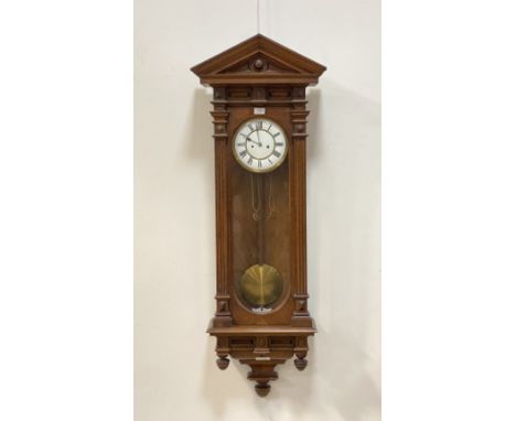 A late 19th century Vienna type regulator wall clock, with arched pediment above a glazed case, white enamel dial with Roman 