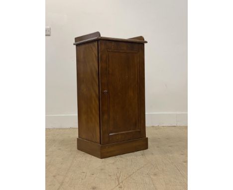 A walnut pedestal bedside cabinet, with galleried top above a panelled door enclosing a shelf, raised on a plinth base H84cm,