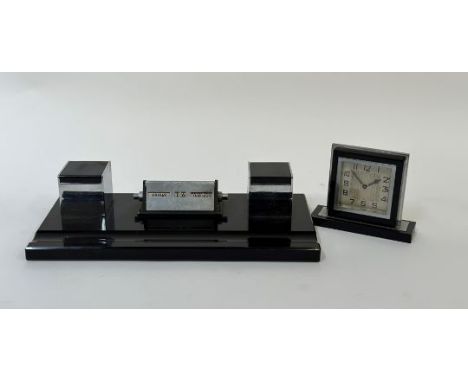 An Art Deco style black glass writing desk set with a built in table calendar, ink well set and pen rest (l- 36cm) and an Art