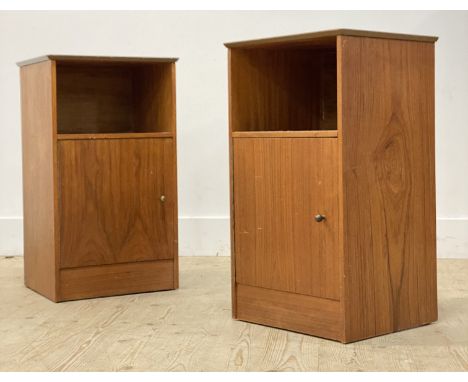 A pair of mid century teak bedside cabinets, each with an open shelf over a cupboard. H69cm, W40cm, D35cm.