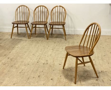 Ercol, a set of four beech and elm hoop and spindle back dining chairs, with saddle seats, raised on turned supports. H82cm.