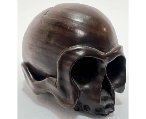 A boxwood momento mori netsuke in the form of a skull (signed verso), the eyes forming a natural himotoshi, with standard him