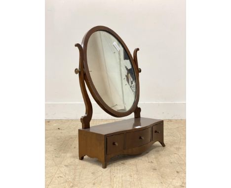 A Georgian style mahogany toilet mirror, the oval plate above a serpentine base fitted with three drawers, raised on splayed 