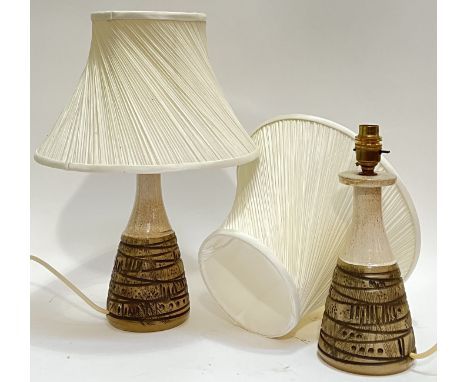 A pair of Poole Pottery lamp bases with abstract moulded/incised decoration and white shades (marked verso, height including 