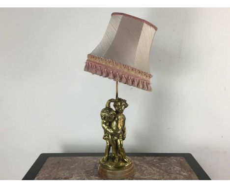 GILT TABLE LAMP, modelled with cherubs on an onyx base, with shade 50cm high