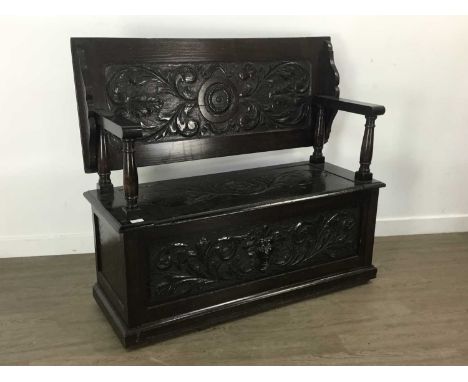 OAK MONKS BENCH, with carved panels, sliding top and hinged seat107cm wideLarge split to carvedback panel. Arms slightly loos