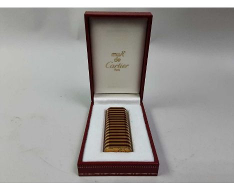 MUST DE CARTIER, TWO CIGAR CUTTERS AND A CIGARETTE LIGHTER the cutters both in pouches and boxed, together with a gold plated
