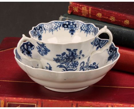 A Worcester Three Flowers pattern ogee shaped chocolate cup and saucer, in underglaze blue, serpent handles, crescent mark, c