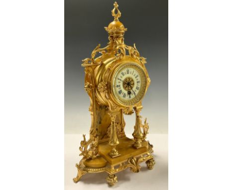 A Louis XVI revival gilt metal mantle clock, crown finial above an enamel dial with Roman numerals and winding with a key, fl