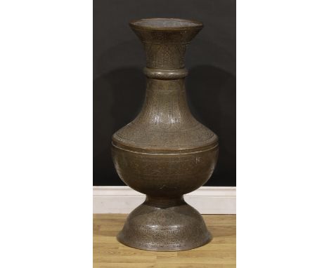 A Middle-Eastern copper floor-standing baluster mosque lamp, pierced and chased with Arabic script and Islamic motifs, 88cm h
