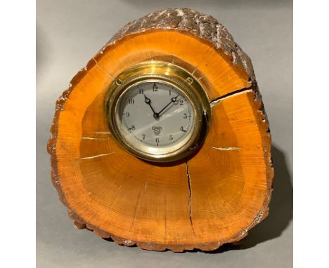 A Smiths motorcar dashboard clock, serial number P-161580, mounted in a polished tree trunk section, 25.5cm high 