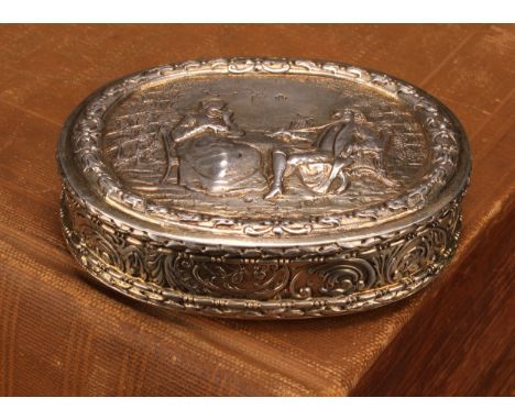 An early 20th century Dutch silver-gilt oval table snuff box, chased with topers and their wives, the side with leafy scrolls