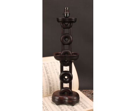 A Japanese hardwood table lamp, geometric pillar pierced with roundels, shaped oval base, 49.5cm to base of fitting, early 20