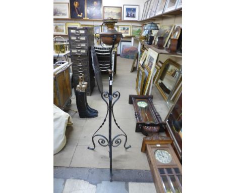 An Art Nouveau wrought iron and copper floor standing oil lamp 