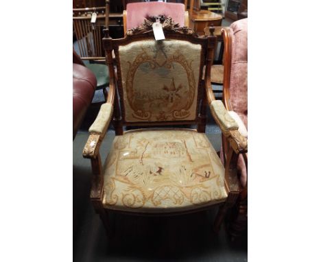 A French walnut carved elbow chair having tapestry upholstery resting on fluted supports