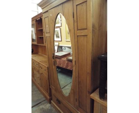 A vintage style pine single wardrobe having central oval bevelled mirror door enclosing hanging compartment above a long draw