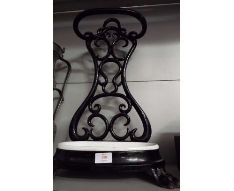 A cast metal stick stand with ceramic base