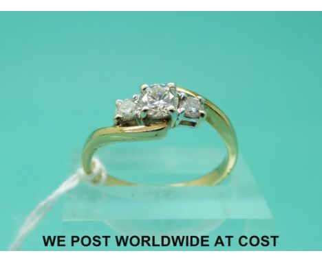 An 18ct gold ring set with three diamonds in a twist setting, the largest diamond measuring approximately 0.35ct (size P)