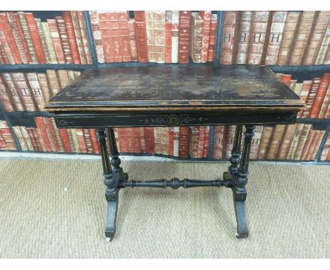 A 19thC ebonised fold over card table in the Shoolbred style, raised on ceramic castors (H72xL88xW43cm)