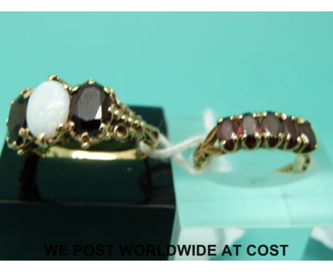 A 9ct gold ring set with garnet (size K) and a 9ct gold ring set with garnets and an opal (size N)