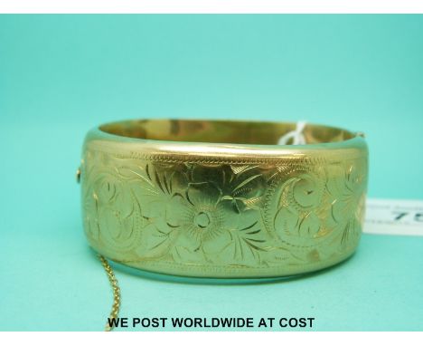 A 9ct gold cuff bangle with engraved decoration of flowers and foliage (30.9g) 