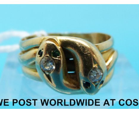 An 18ct gold ring in the form of two snakes each set with an old cut diamond and with emerald and sapphire eyes, 5g (size J)