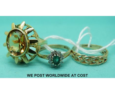 A 9ct gold ring set with an emerald surround by diamonds, a yellow metal ring set with a large oval citrine and a plaited 9ct