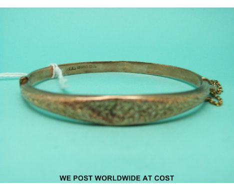 A 9ct gold bangle with foliate decoration (6.2g)