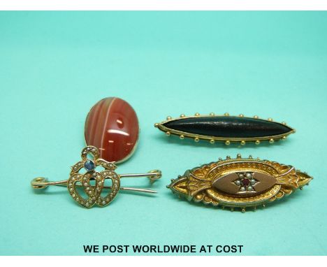 An Edwardian brooch in the form of two hearts set with seed pearls and a sapphire, a yellow metal brooch set with jet, a 9ct 
