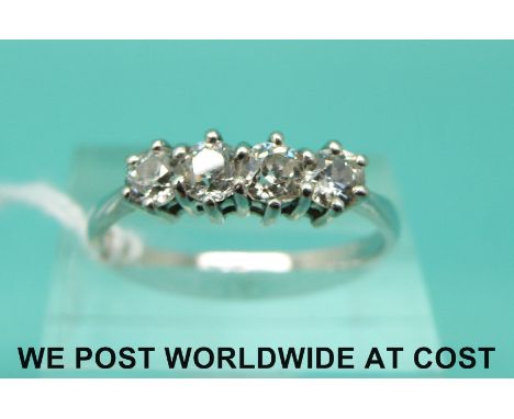 A white metal ring marked 18ct set with four old cut diamonds (size R)