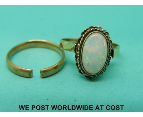 A 9ct gold ring set with an opal and a yellow metal band