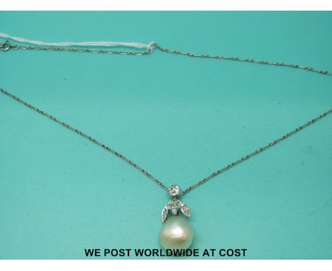 A platinum pendant set with a large baroque pearl and old cut diamonds, the largest approximately 0.25ct, on a platinum chain