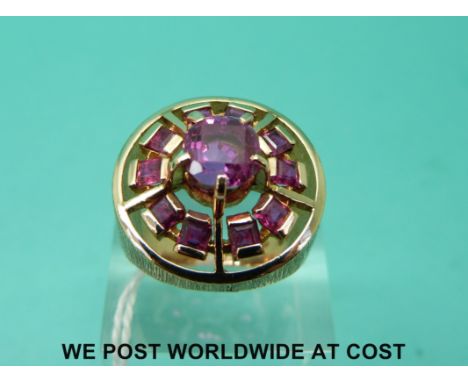 An 18ct gold ring set with pink sapphires in a circular setting with textured surround (size P)