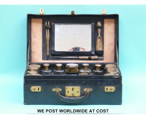 A leather cased A. Girardeau Paris French silver gilt travelling set, comprising bevelled edge mirror with easel back, shoe h