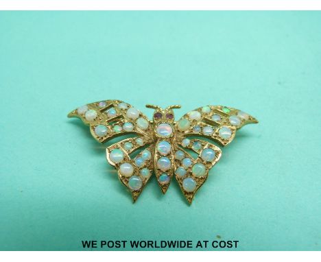 A 9ct gold brooch in the form of a butterfly or moth set with opals and with ruby eyes 