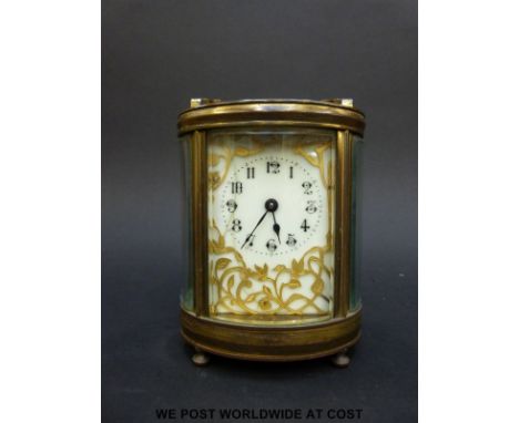 A mantel clock of oval section with bevelled glass and pierced gilt foliate panel to dial 