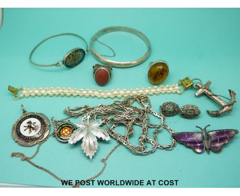 A quantity of silver jewellery to include a bangle, a silver ring, silver earrings, a pearl bracelet, brooches, football meda