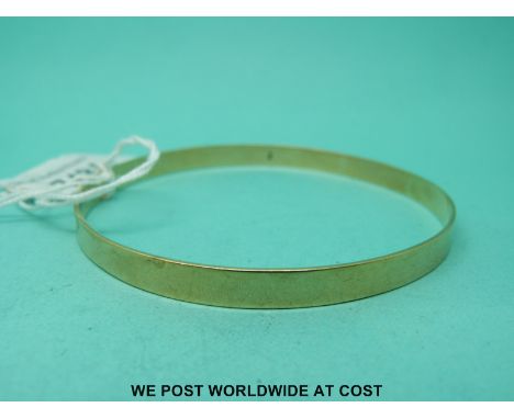 A yellow metal bangle marked 9ct gold (12.6g)