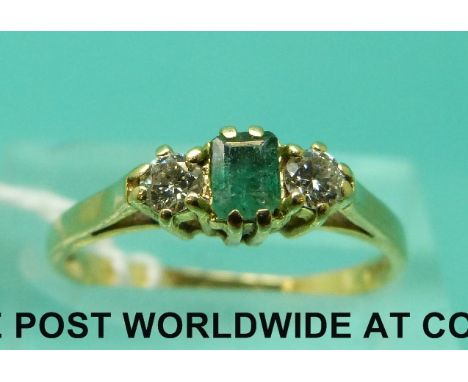 An 18ct gold ring set with a a square emerald and two diamonds (size K)