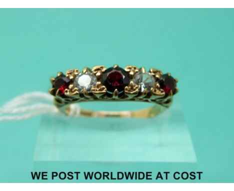 A 9ct gold ring set with alternate garnet and clear stones (size K/L)