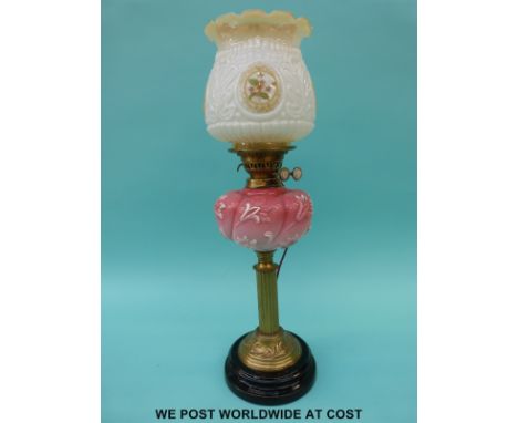 A late 19th / early 20thC brass and glass oil lamp converted to electricity with pink relief moulded reservoir and white glas
