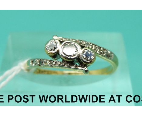 An 18ct gold ring set with three diamonds in a platinum setting, the shoulders encrusted with further diamonds (size J)