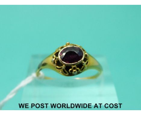  A Victorian yellow metal ring set with an amethyst in a pierced setting (size N)