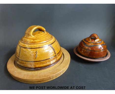A Winchcombe Pottery cheese board with a dome and another smaller example